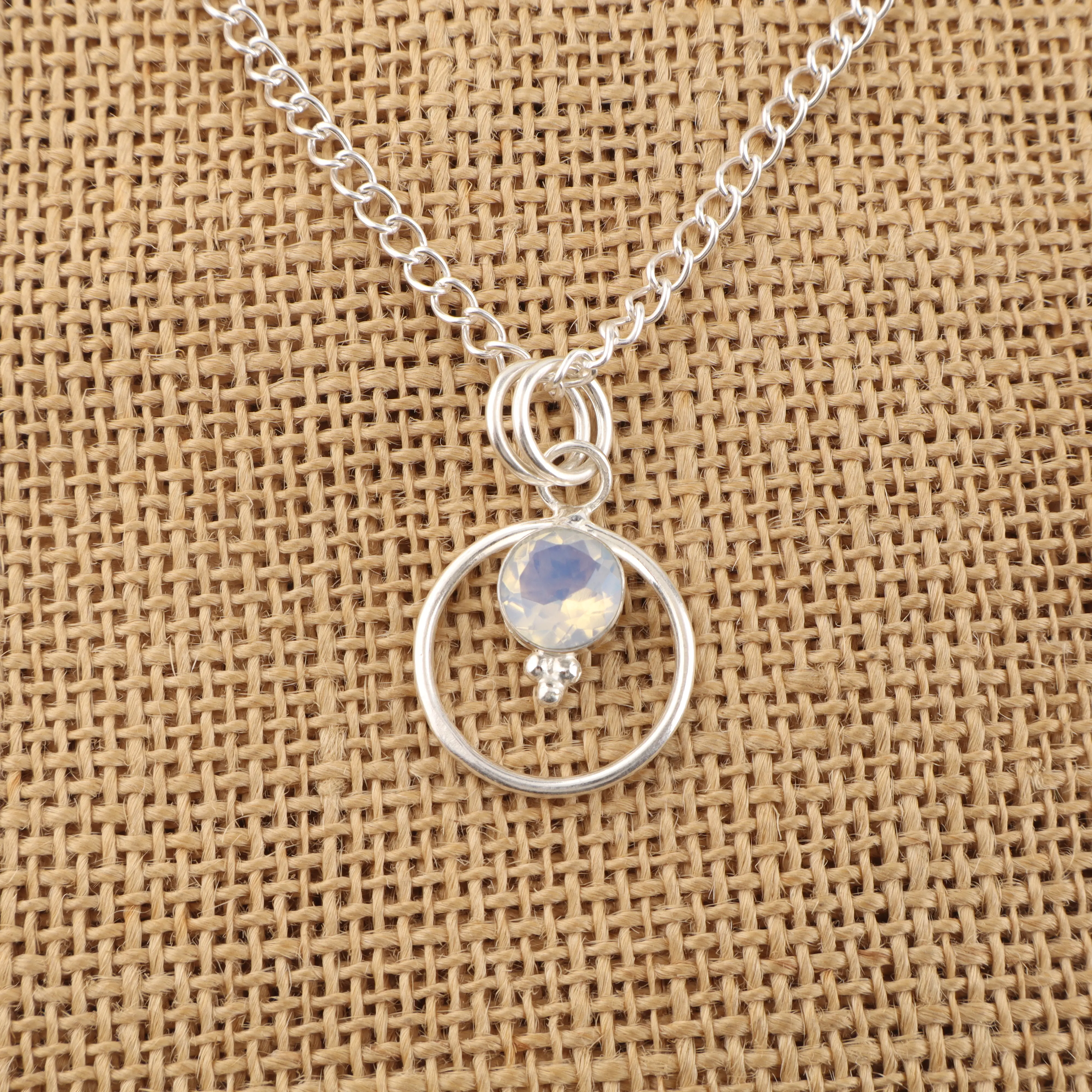 Milky opal pendant with white gemstone and soft iridescent glow in elegant handcrafted setting