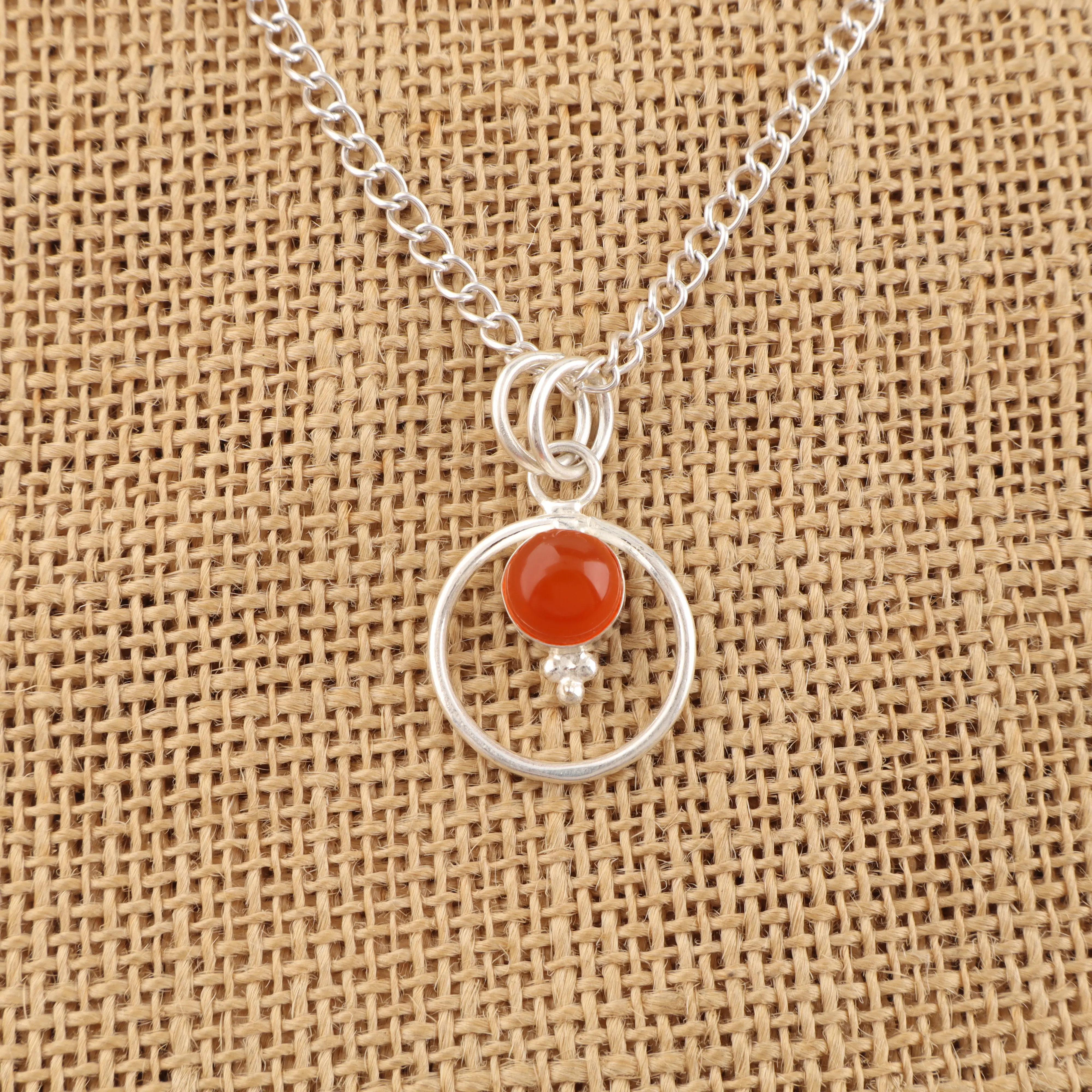 Carnelian pendant in sterling silver with vibrant orange-red gemstone